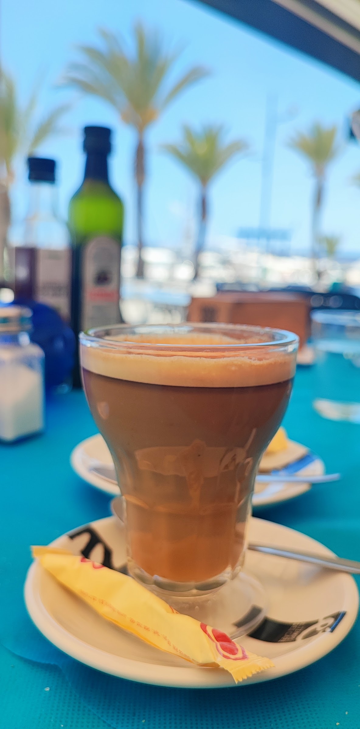 Café con vistas a las palmeras y los barcos